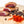 Load image into Gallery viewer, Chunks of duck prosciutto on a cutting board with herbs and spices in the foreground.
