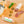 Load image into Gallery viewer, A product photo of green chile tequila salami shot from above. Half of the salami is whole and the other half is cut into slices on a cutting board with a tequila bottle, a green chile, herbs and spices.