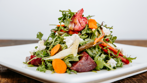 il porcellino salumi's root vegetable salad pictured up-close and displayed on a white plate.