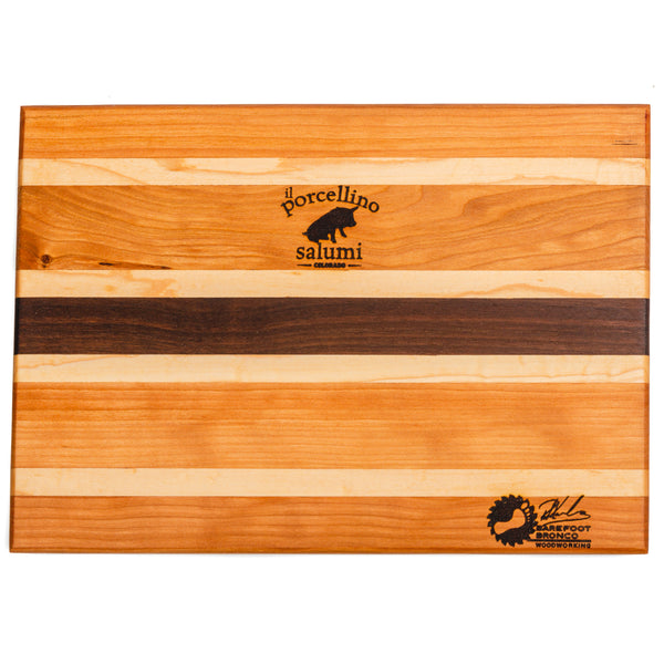A product photo of a cutting board with the il porcellino salumi and barefoot bronco logos burned into the board.